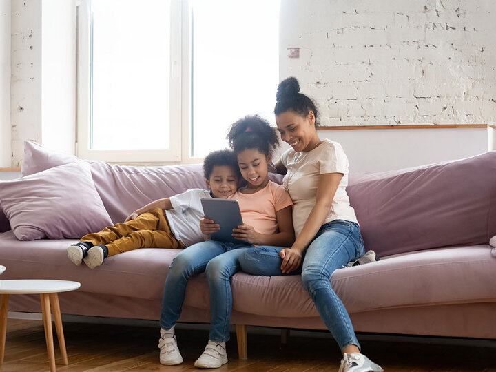 Kids looking at a computer with their mom.
