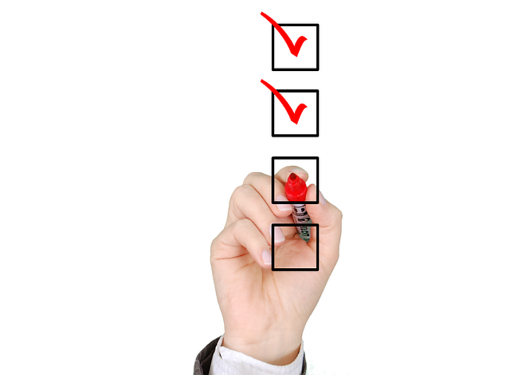hand checking off a box with a red marker