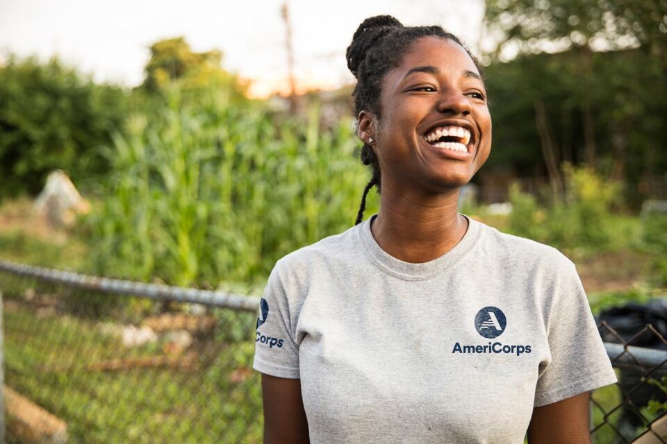 Girl in an AmeriCorp shirt laughing.